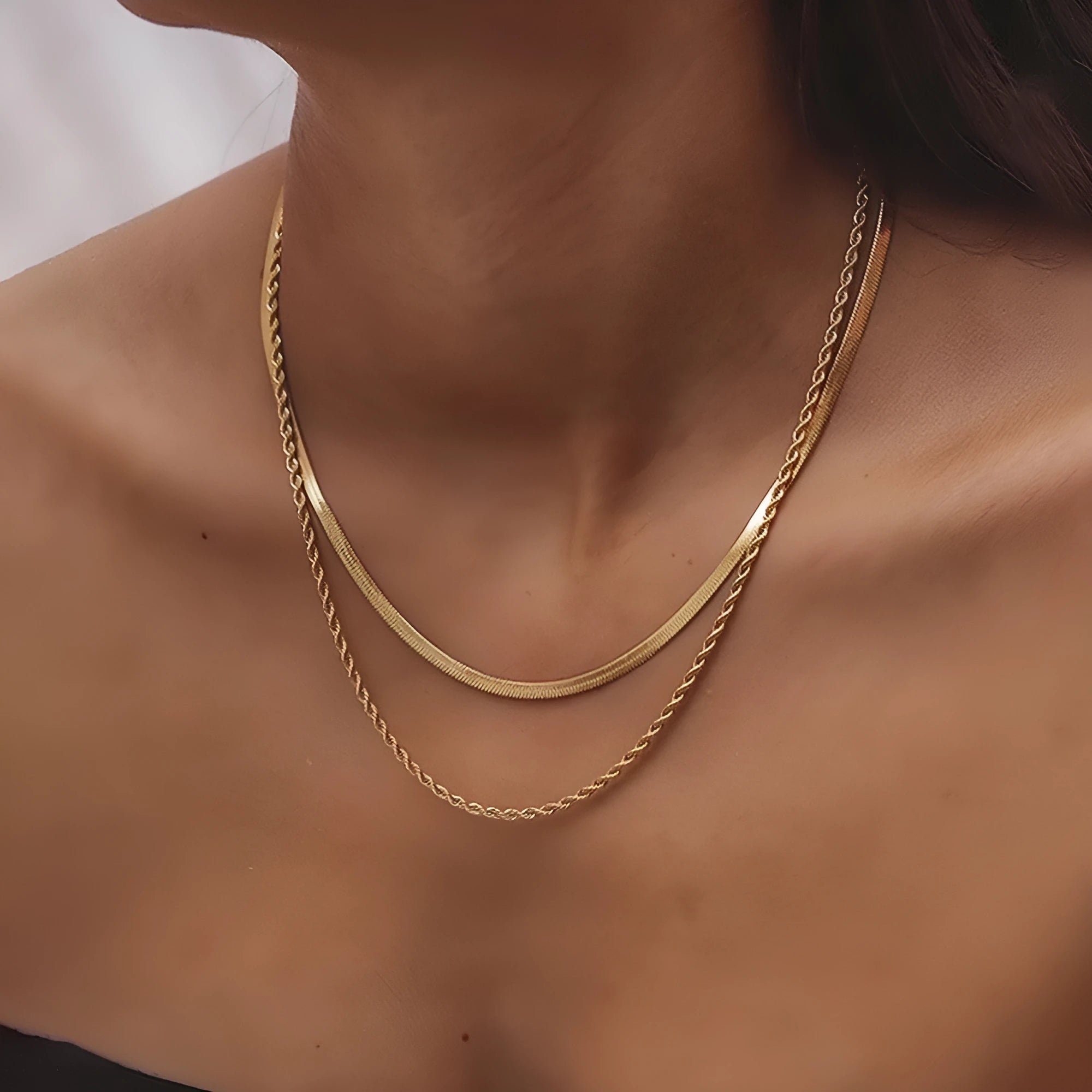 Women's double-layer twist necklace with geometric titanium steel pendant on an adjustable snake bone chain.
