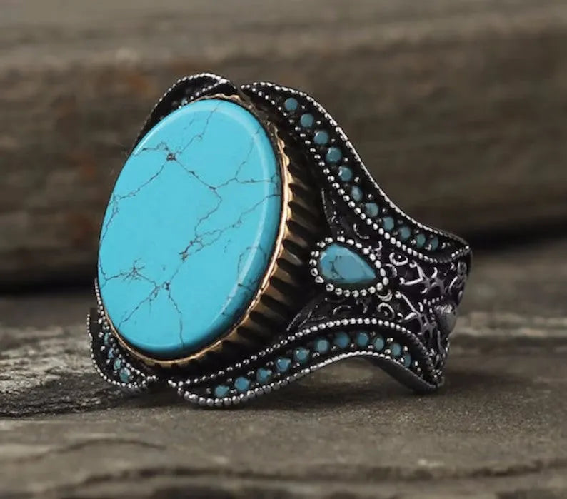 Men's antique silver round turquoise alloy ring on a plain background