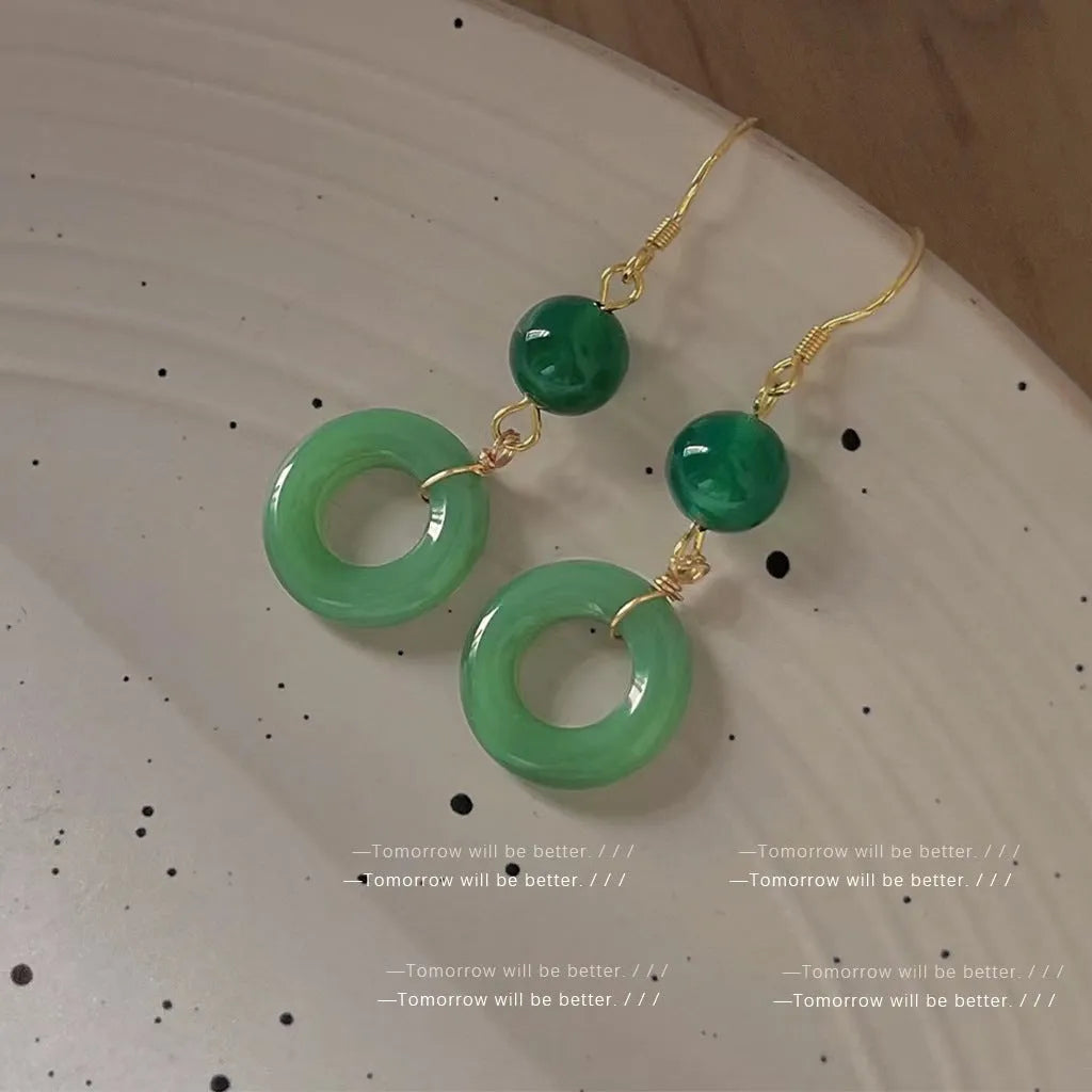 Pair of green jade design earrings with a geometric peace buckle shape on a zinc alloy base with gold plating.