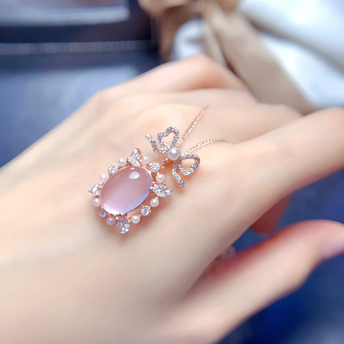 Geometric silver pendant necklace with a natural pink rose quartz crystal and a rose gold-plated setting.