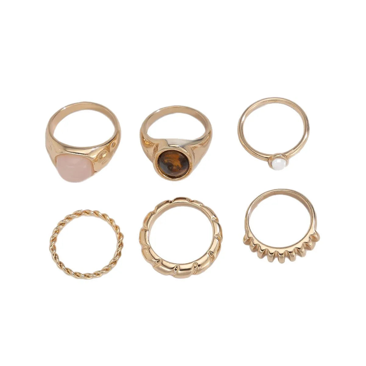 Six geometric alloy rings in light gold finish arranged for display