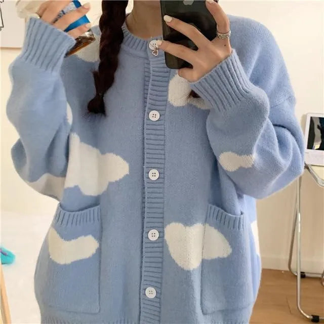 Blue women's loose cardigan with white cloud pattern, long sleeves, shown on a hanger.
