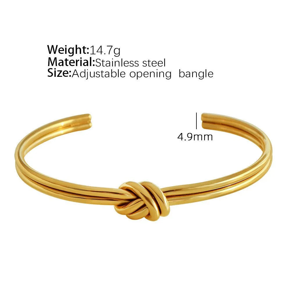 Women's stainless steel C-shaped knotted open bracelet with gold or silver electroplated finish.