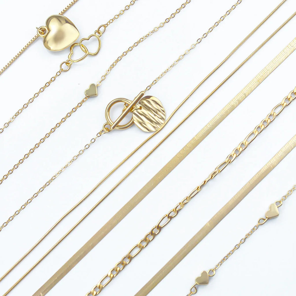 Ten gold-coloured women's necklaces with different alloy pendants on snake bone chains