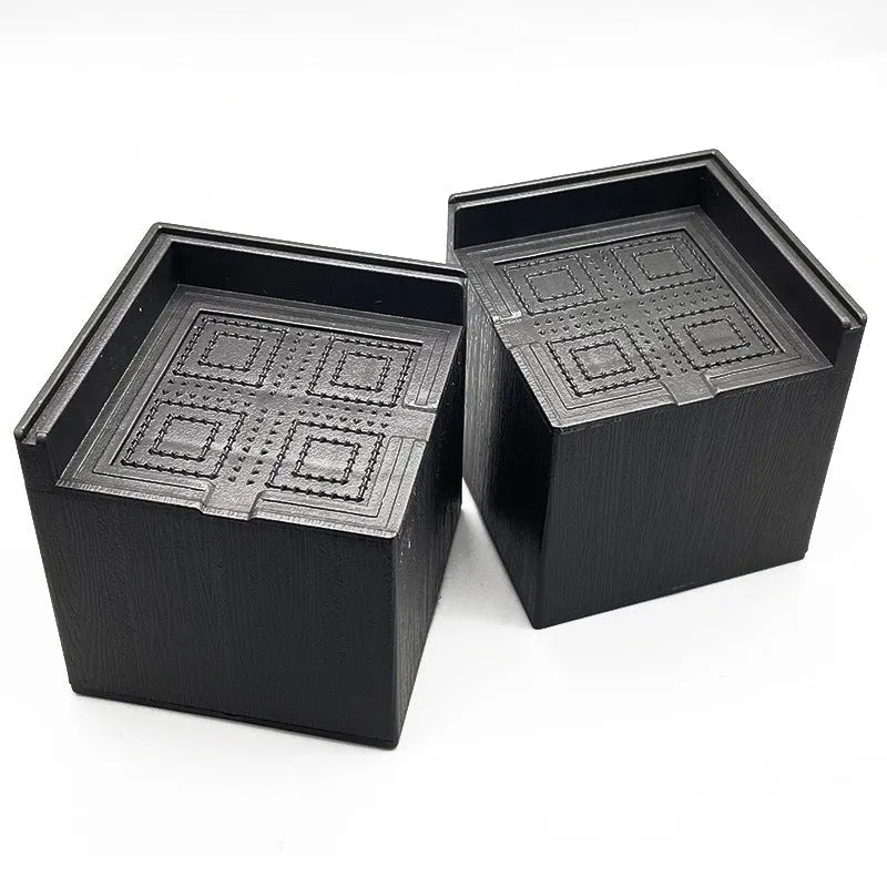 Four black plastic furniture foot mats for sofa and bed height adjustment