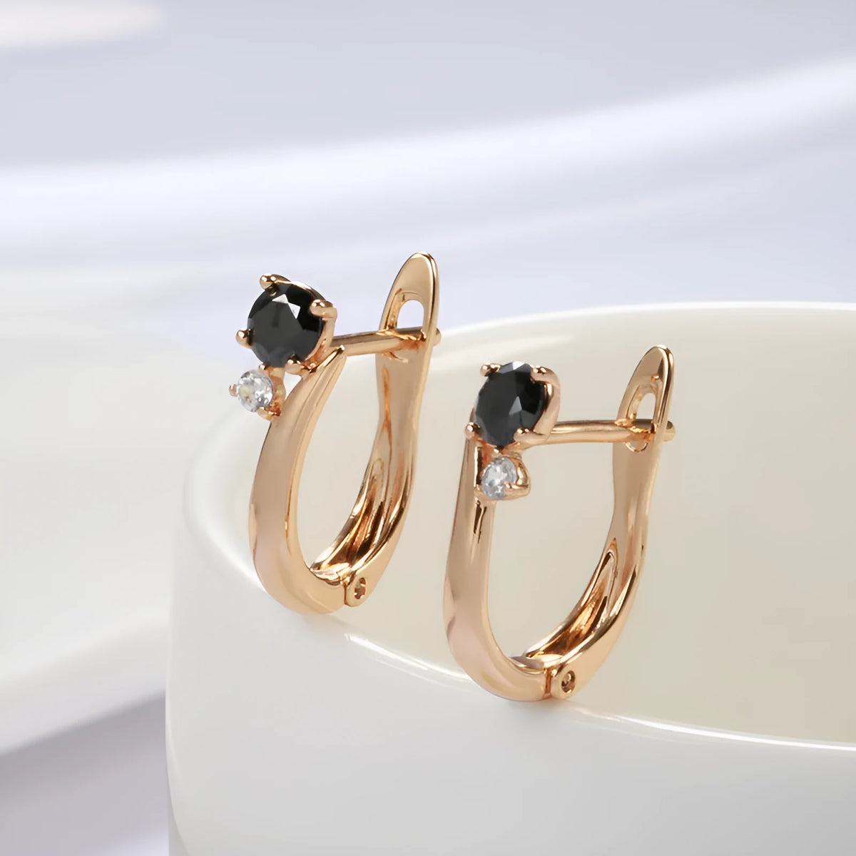 Women's gold drop earrings with black agate geometric design and clip-on back