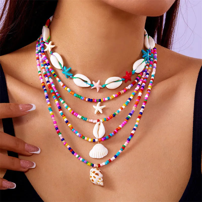 Blue and coloured multi-layer women's necklace set with starfish, shell, and conch beads on adjustable chain.