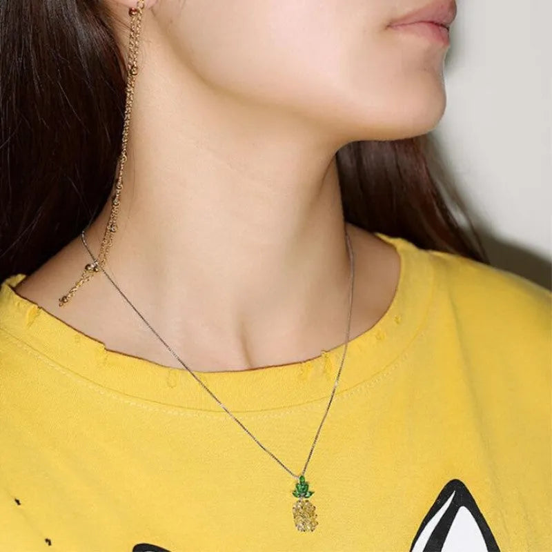 Silver geometric pineapple necklace with diamond-style stones on model