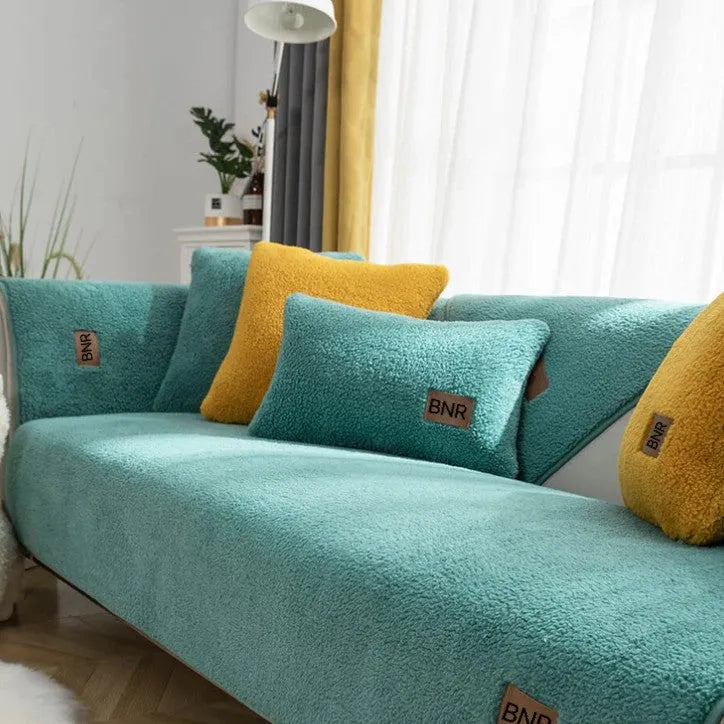 Lambswool solid colour sofa cover in blue, shown draped over a sofa arm.