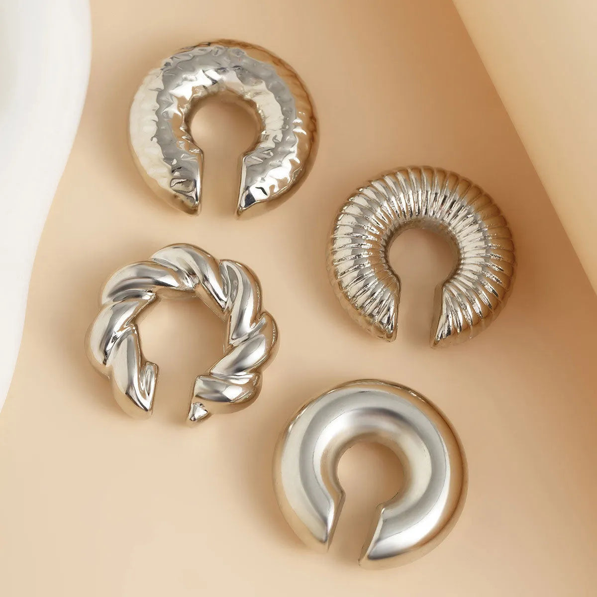 Set of four geometric gold and silver clip-on earrings for women without pierced ears.