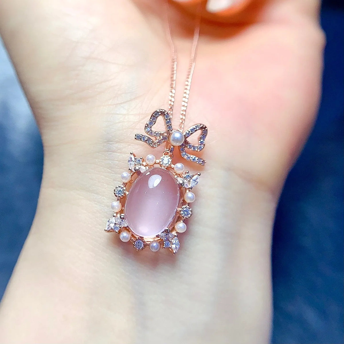 Geometric silver pendant necklace with a natural pink rose quartz crystal and a rose gold-plated setting.
