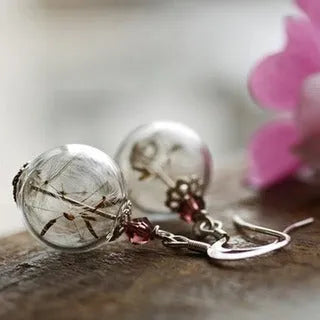 Transparent glass ball earrings with dandelion seed designs on French hooks in silver and bronze finishes