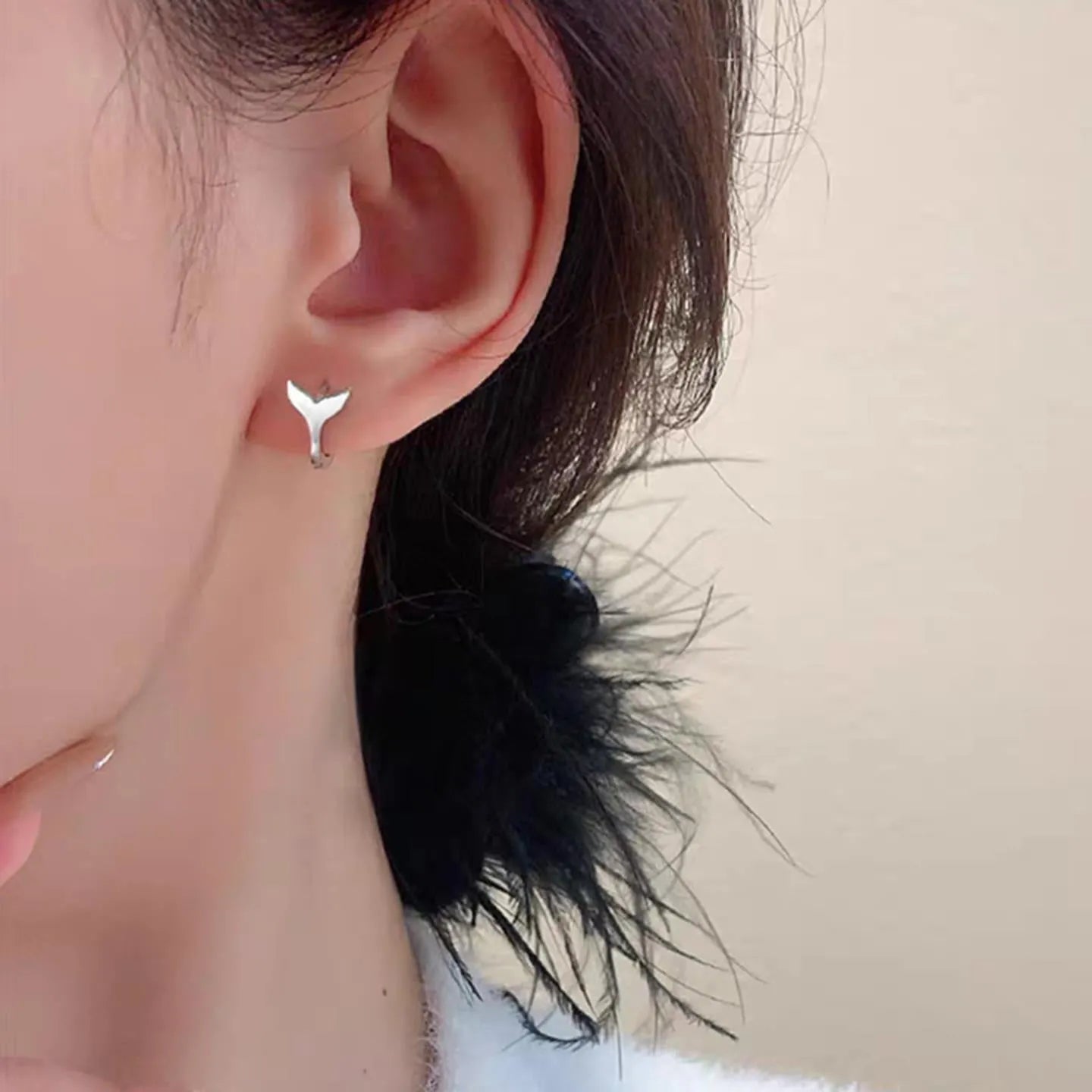 A pair of women's fishtail design earrings in copper with a white gold or yellow gold electroplated finish.