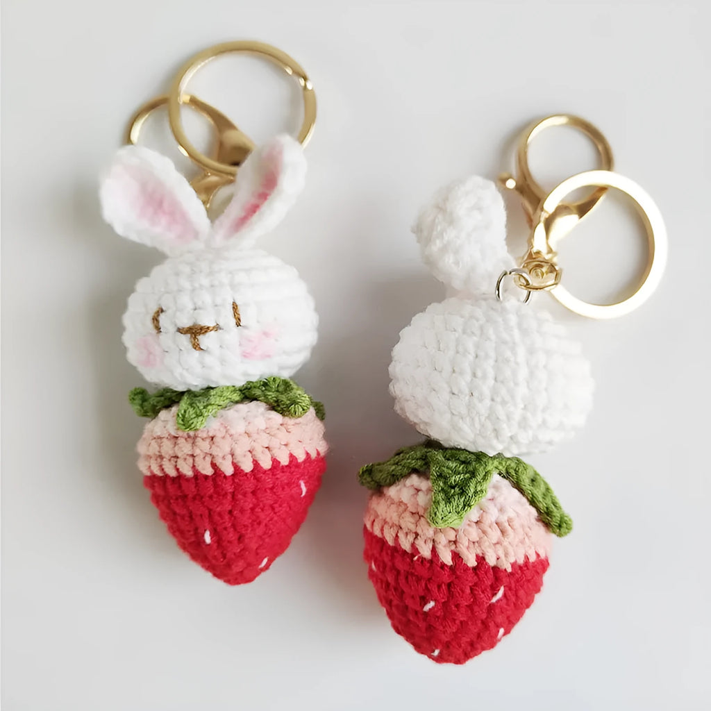 White hand-woven wire rabbit pendant with cartoon strawberry pattern and key attachment