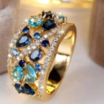 Copper hollow fashion ring for women in a round design, shown in gold and platinum with blue and white stone accents.