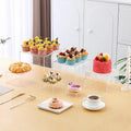 White plastic modular cube dessert display stand with six stackable units for cakes and pastries