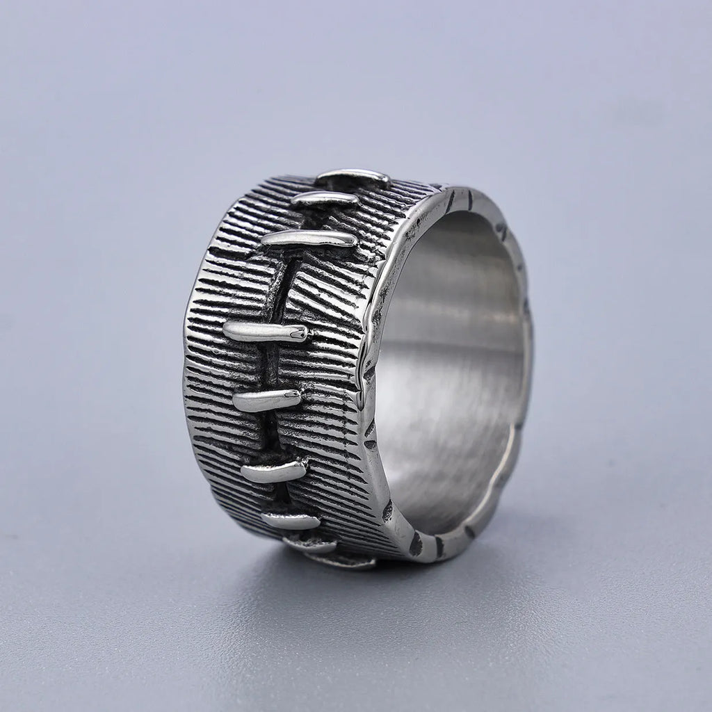Geometric dark punk double ring in titanium steel on a black background, showing its U-shaped silhouette.