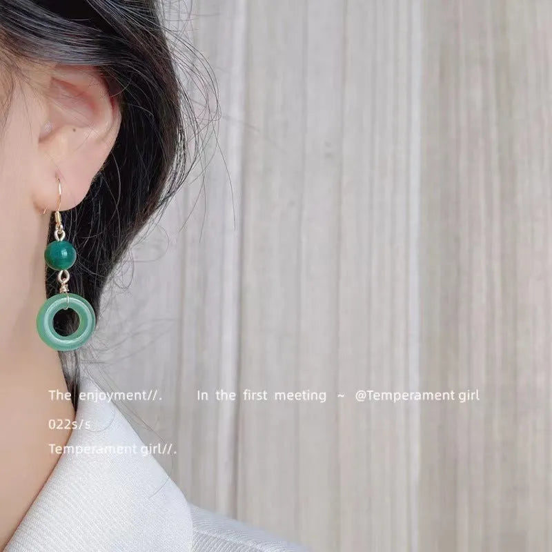 Pair of green jade design earrings with a geometric peace buckle shape on a zinc alloy base with gold plating.