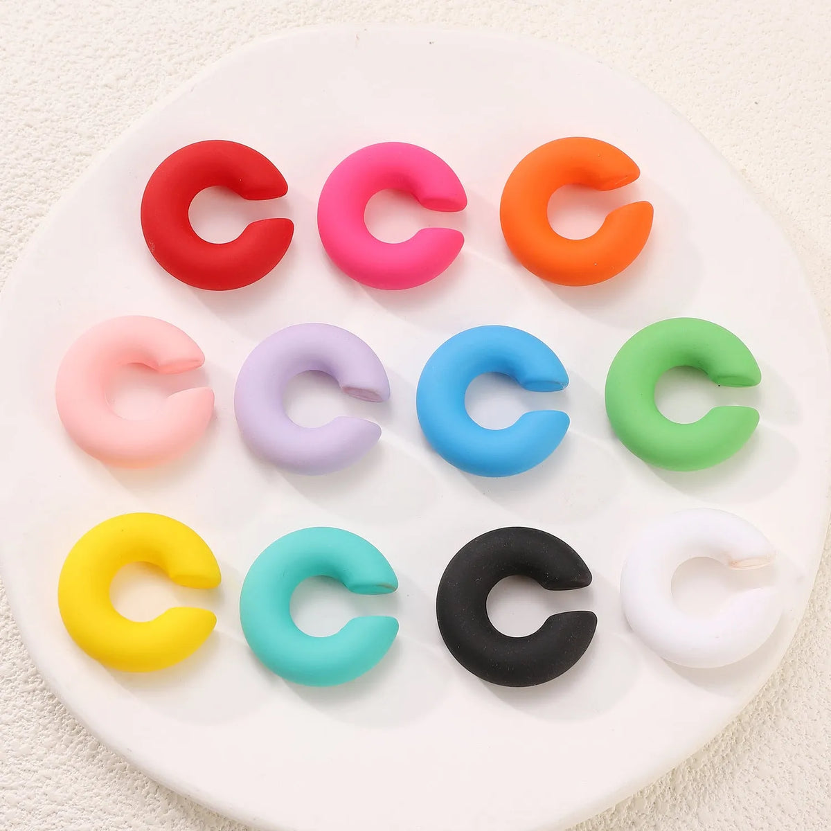 C-shaped geometric clip-on earrings with matte coarse finish in a selection of candy colours