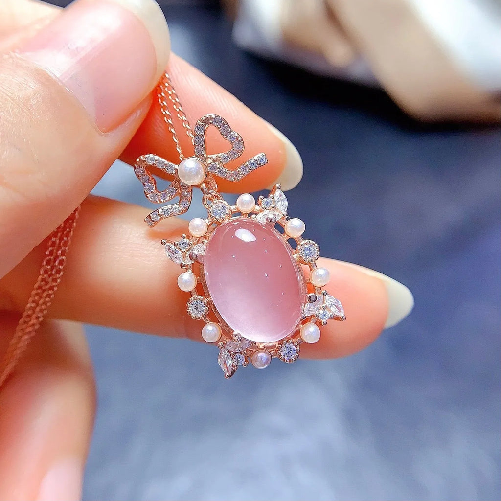Geometric silver pendant necklace with a natural pink rose quartz crystal and a rose gold-plated setting.
