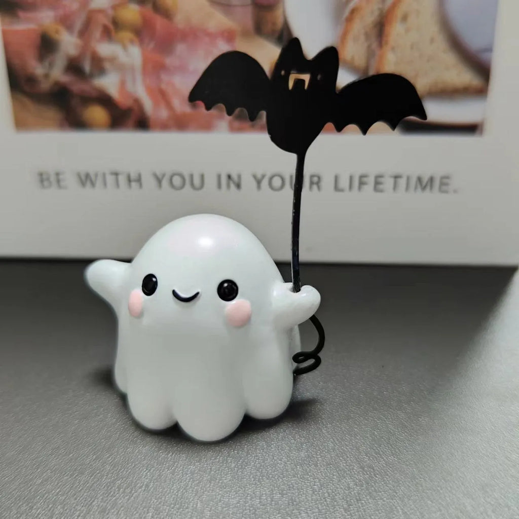 Small resin Halloween statue of a ghost walking a dog and holding a bat.