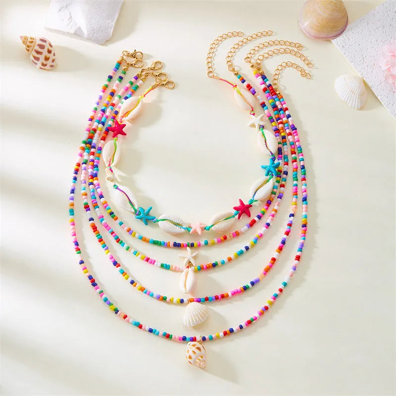 Blue and coloured multi-layer women's necklace set with starfish, shell, and conch beads on adjustable chain.