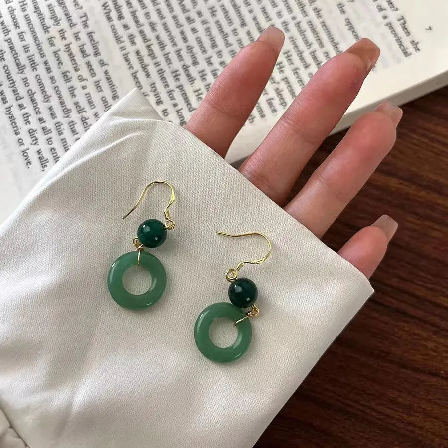 Pair of green jade design earrings with a geometric peace buckle shape on a zinc alloy base with gold plating.