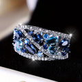 Copper hollow fashion ring for women in a round design, shown in gold and platinum with blue and white stone accents.