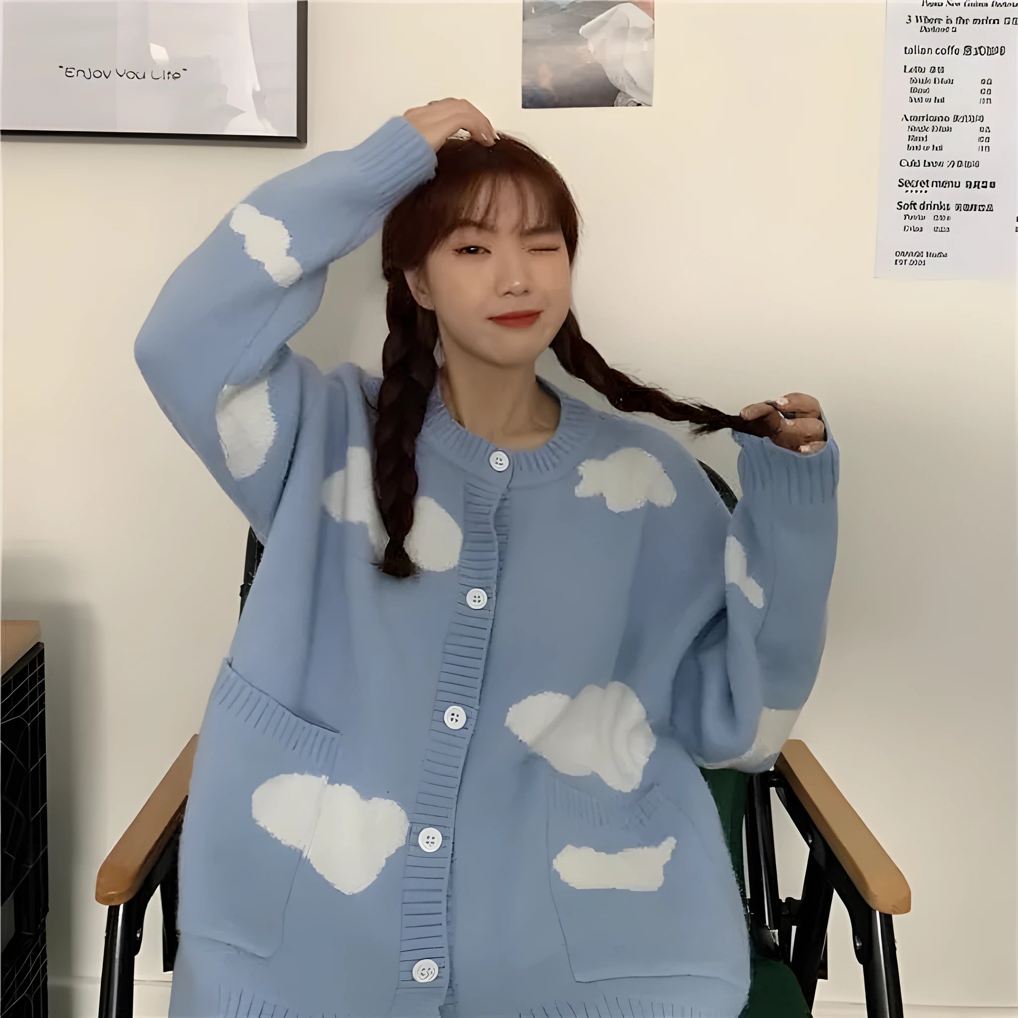 Blue women's loose cardigan with white cloud pattern, long sleeves, shown on a hanger.
