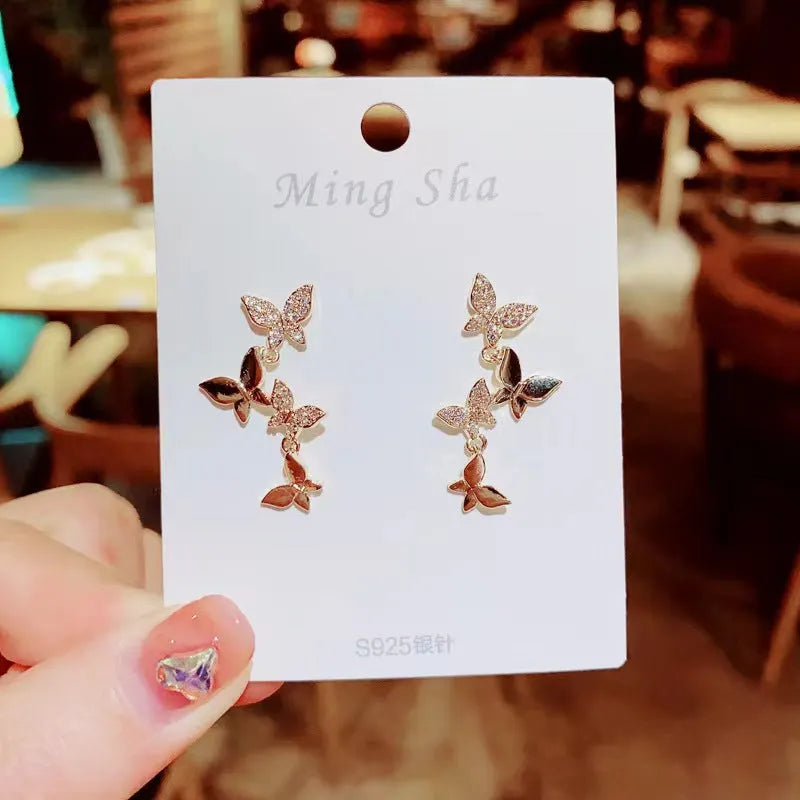 Women's gold-coloured copper earrings with four butterfly design elements in drop style