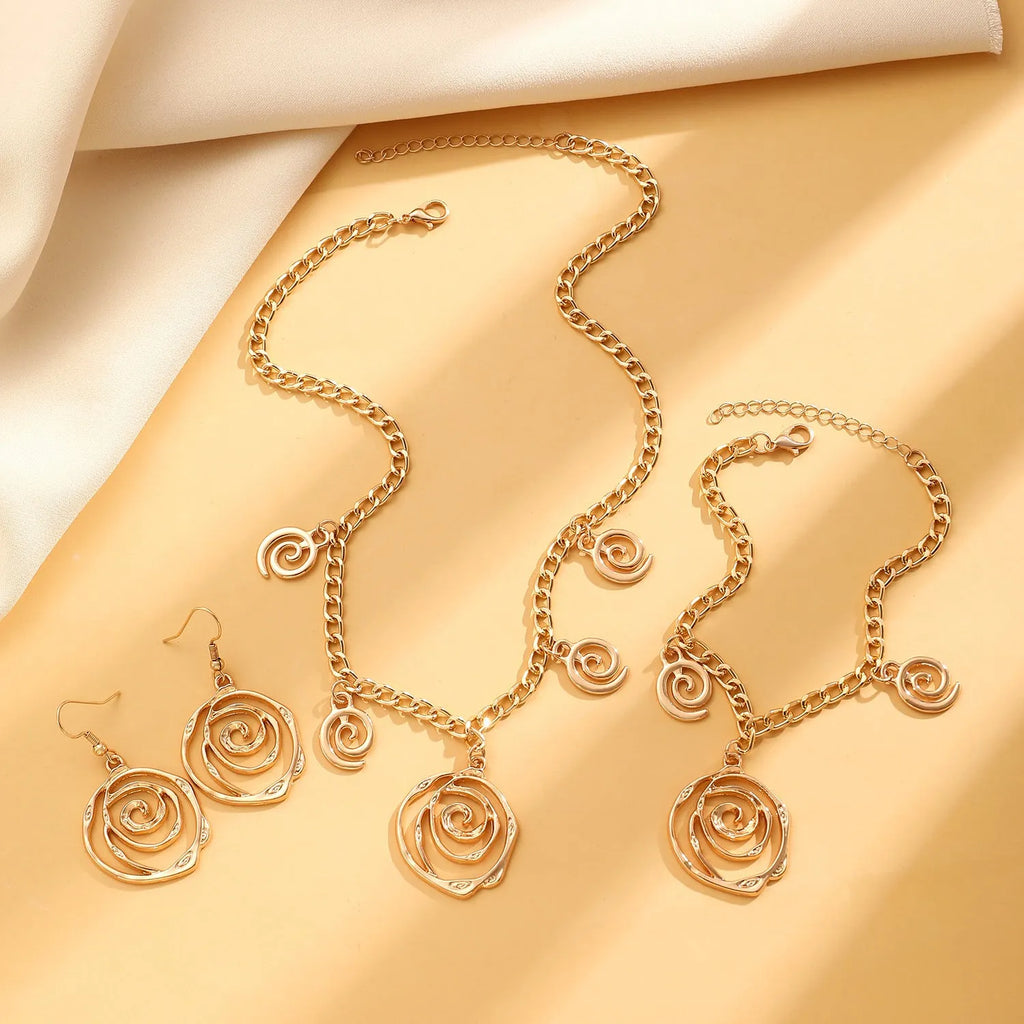 Spiral donut jewellery set showing necklace, bracelet and earrings in gold tone geometric circle design