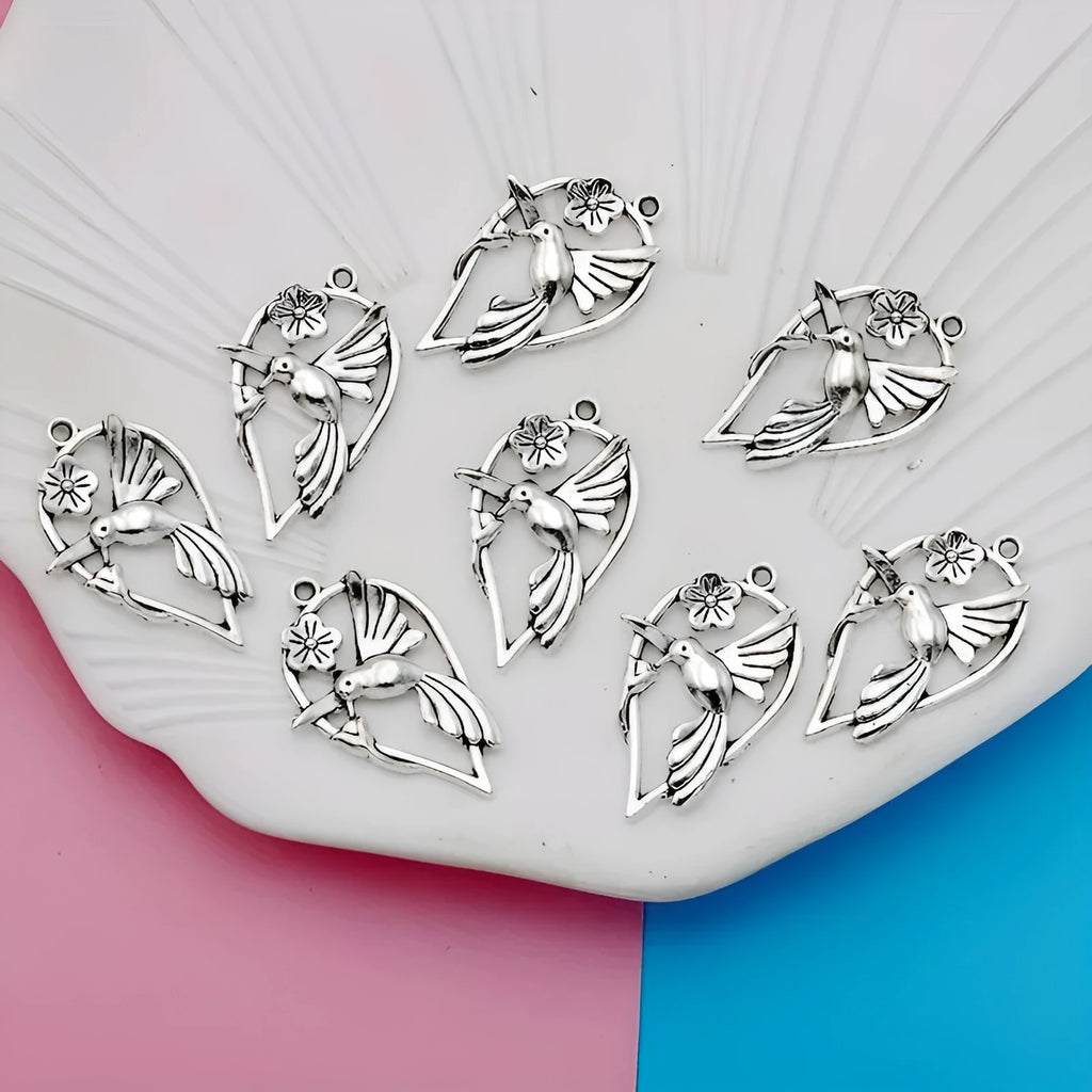 Close-up of an alloy pendant charm featuring a detailed magpie or cuckoo bird design with an electroplated finish.
