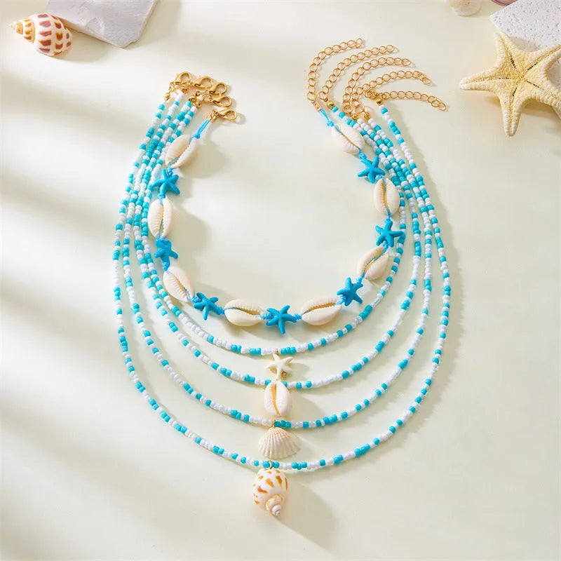 Blue and coloured multi-layer women's necklace set with starfish, shell, and conch beads on adjustable chain.