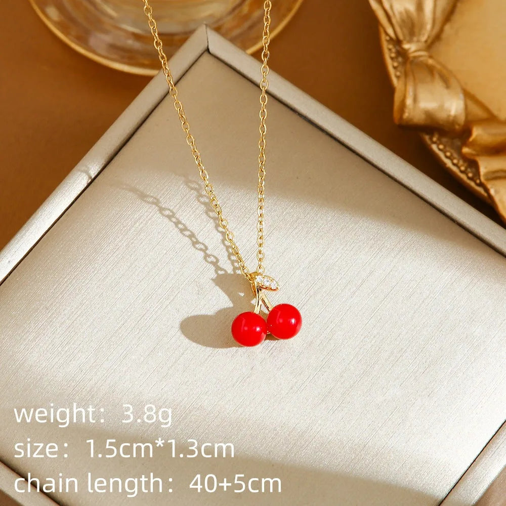 Delicate titanium steel necklace with a small cherry charm on an O-ring chain, gold finish.