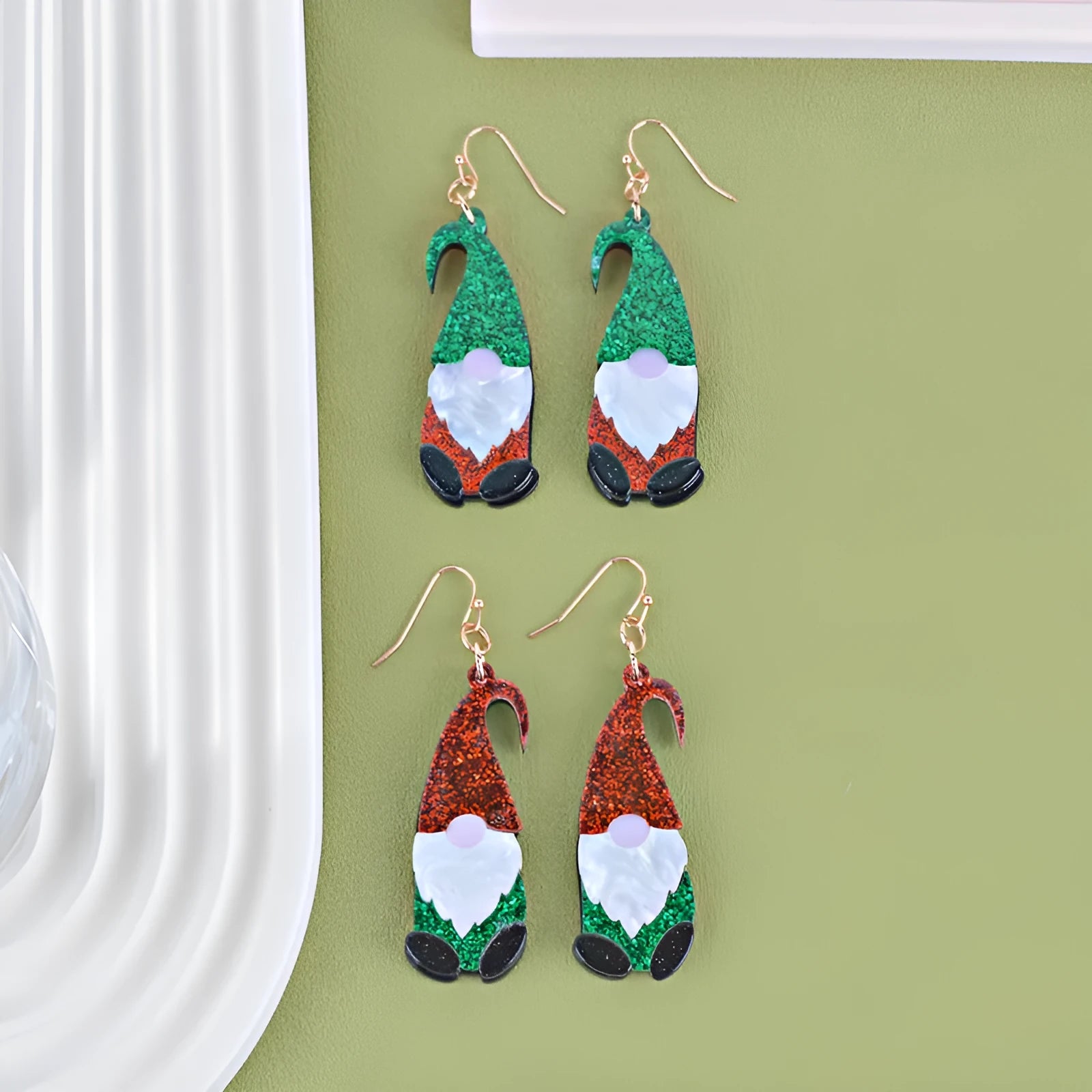 A pair of colourful Santa Claus cartoon character earrings made from acrylic, showing red and green hat style options.