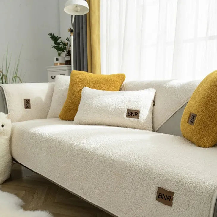 Lambswool solid colour sofa cover in blue, shown draped over a sofa arm.