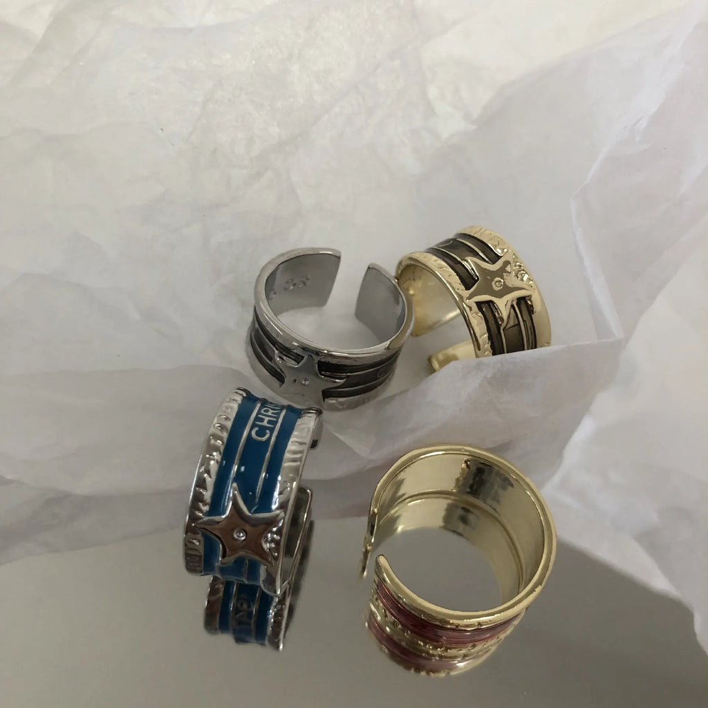 Adjustable distressed geometric ring with line design in electroplated black, blue, or red.