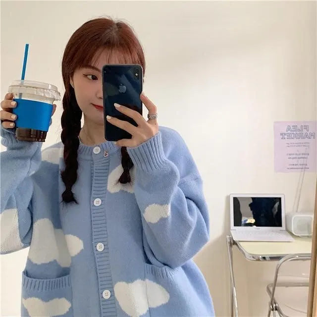 Blue women's loose cardigan with white cloud pattern, long sleeves, shown on a hanger.