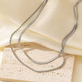 Women's double-layer twist necklace with geometric titanium steel pendant on an adjustable snake bone chain.