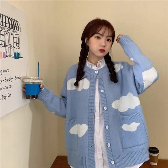 Blue women's loose cardigan with white cloud pattern, long sleeves, shown on a hanger.
