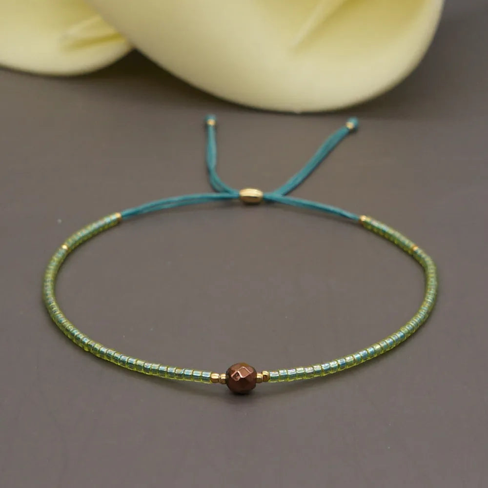Close-up of a colourful handmade Bohemian bracelet with semi-precious stone and glass geometry beads on a wrist.