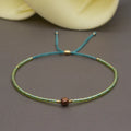 Close-up of a colourful handmade Bohemian bracelet with semi-precious stone and glass geometry beads on a wrist.