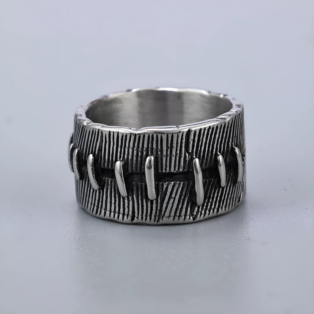 Geometric dark punk double ring in titanium steel on a black background, showing its U-shaped silhouette.