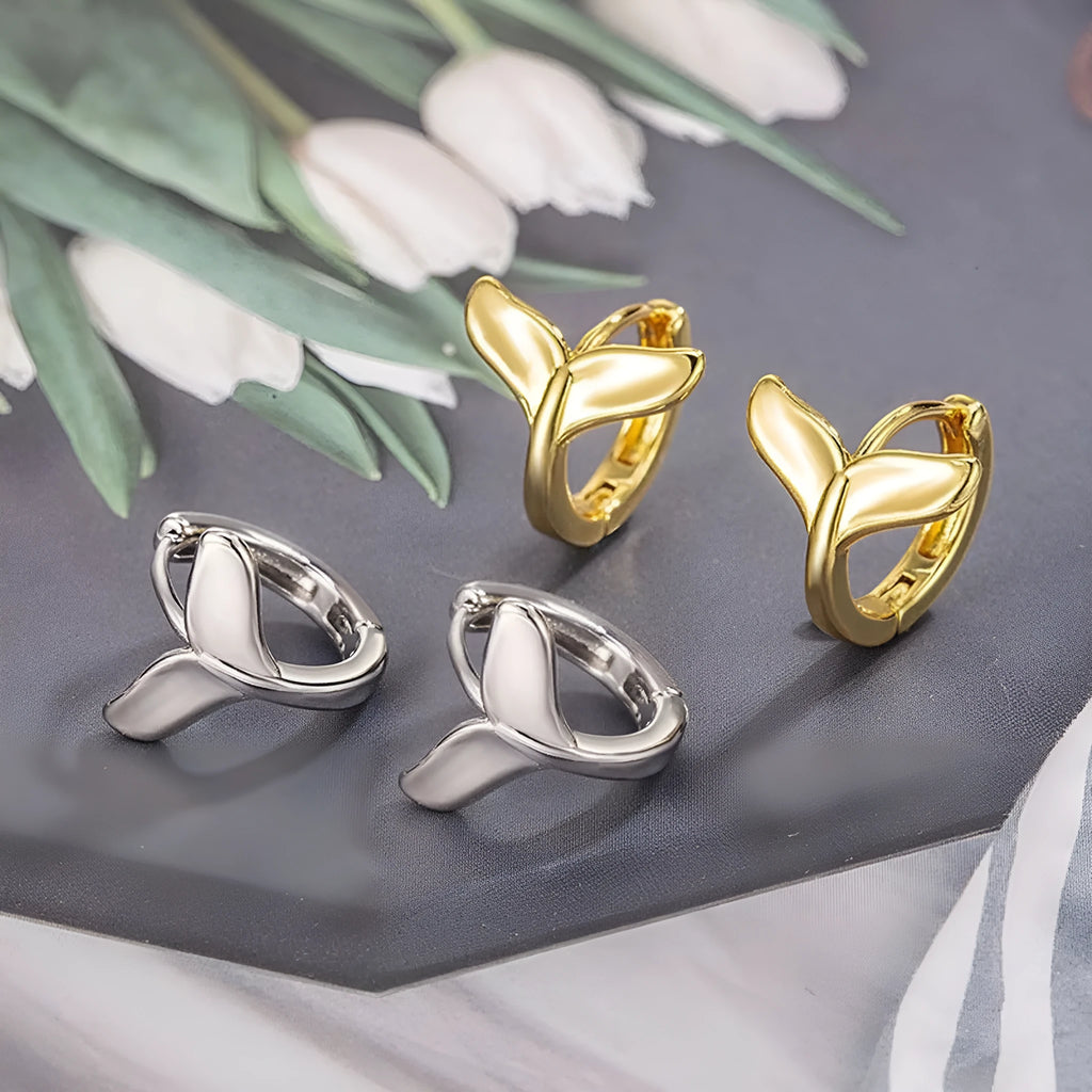A pair of women's fishtail design earrings in copper with a white gold or yellow gold electroplated finish.