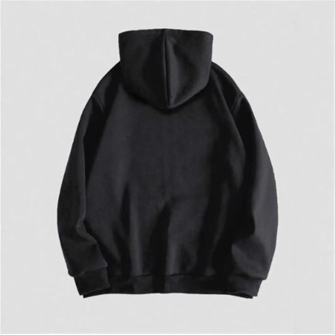 Man wearing a black hooded sweatshirt with a large green skull graphic print on the front.
