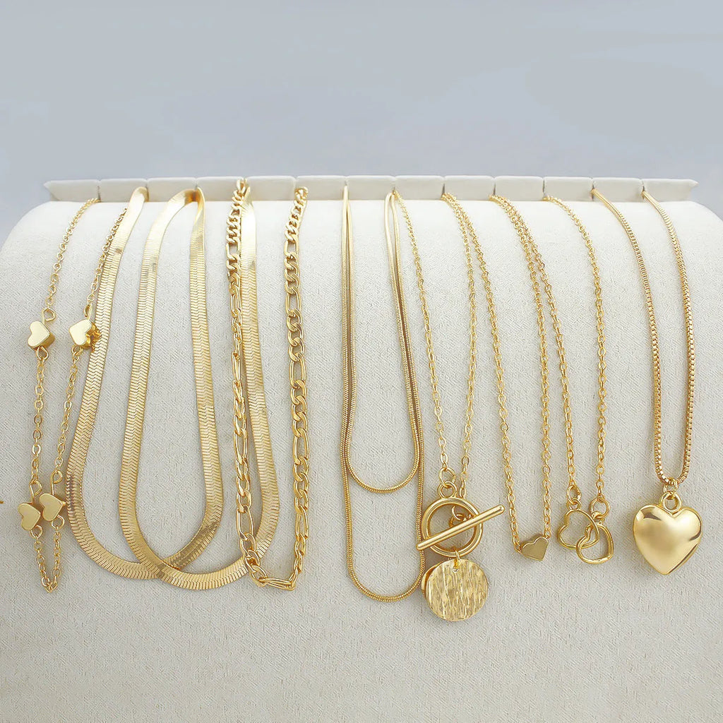 Ten gold-coloured women's necklaces with different alloy pendants on snake bone chains