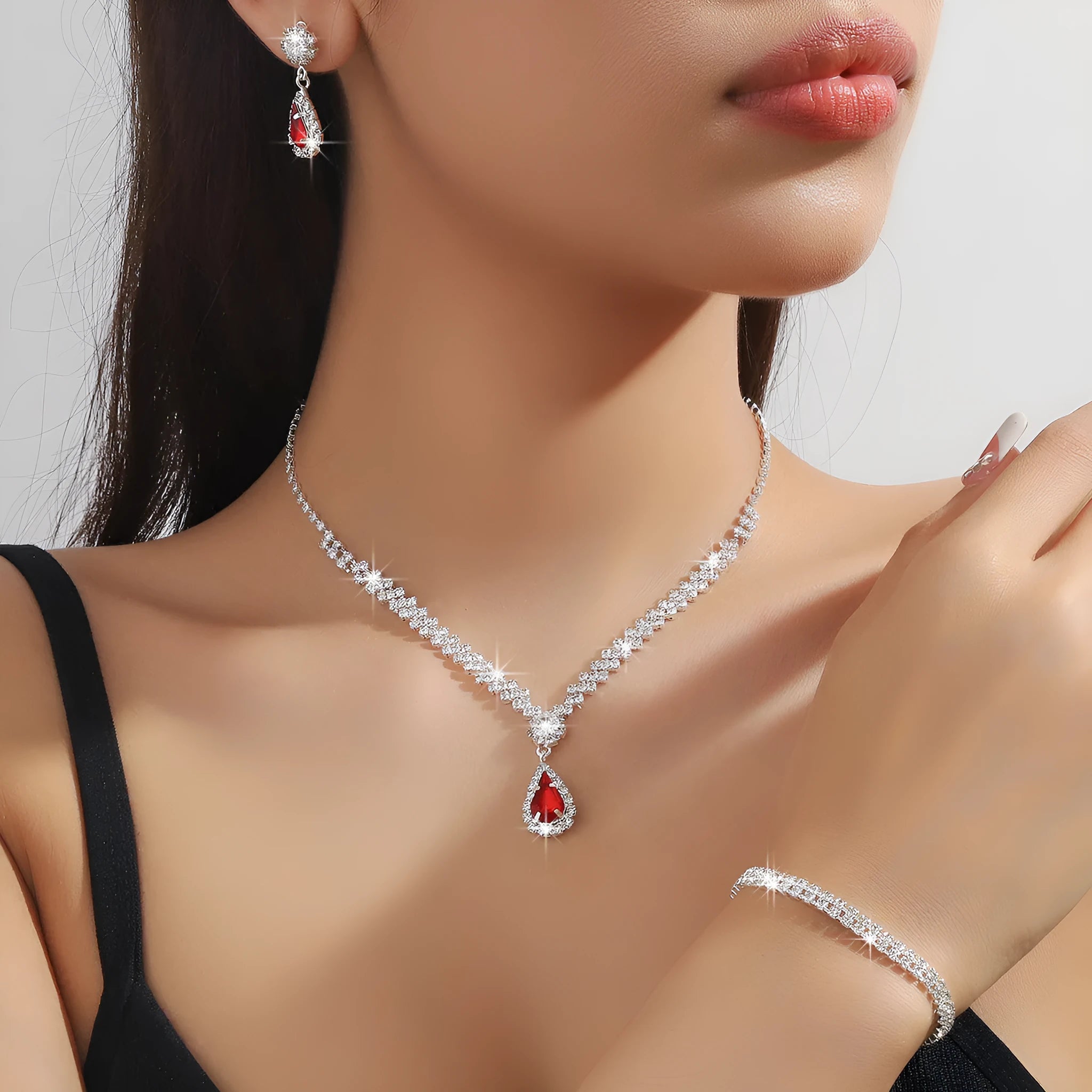 Claw chain necklace and matching earrings set with drop-shaped rhinestones in blue colour