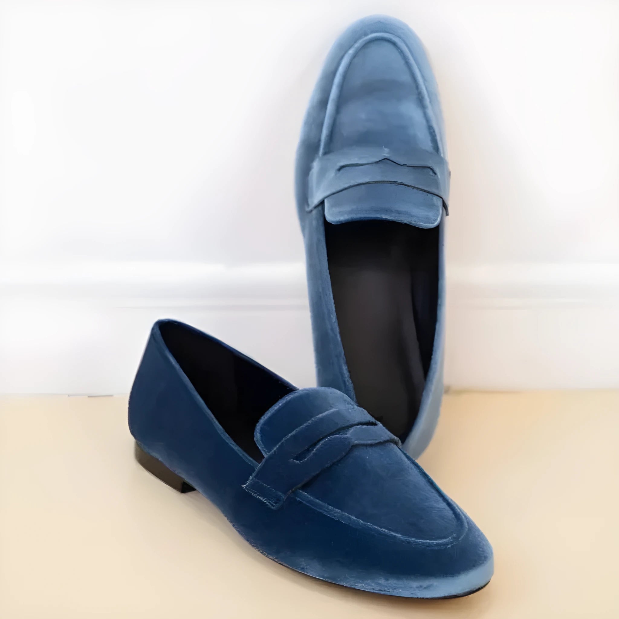 Blue leisure loafers with a black rubber sole and round toe design on a white background