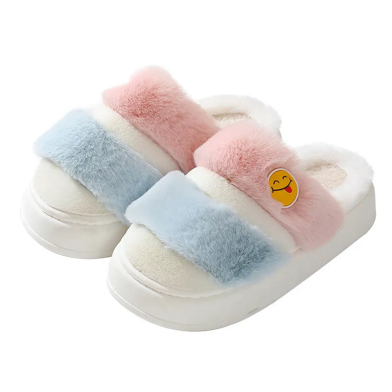 Pink and green cartoon thermal cotton slippers with plush upper and cashmere lining on a wooden floor.