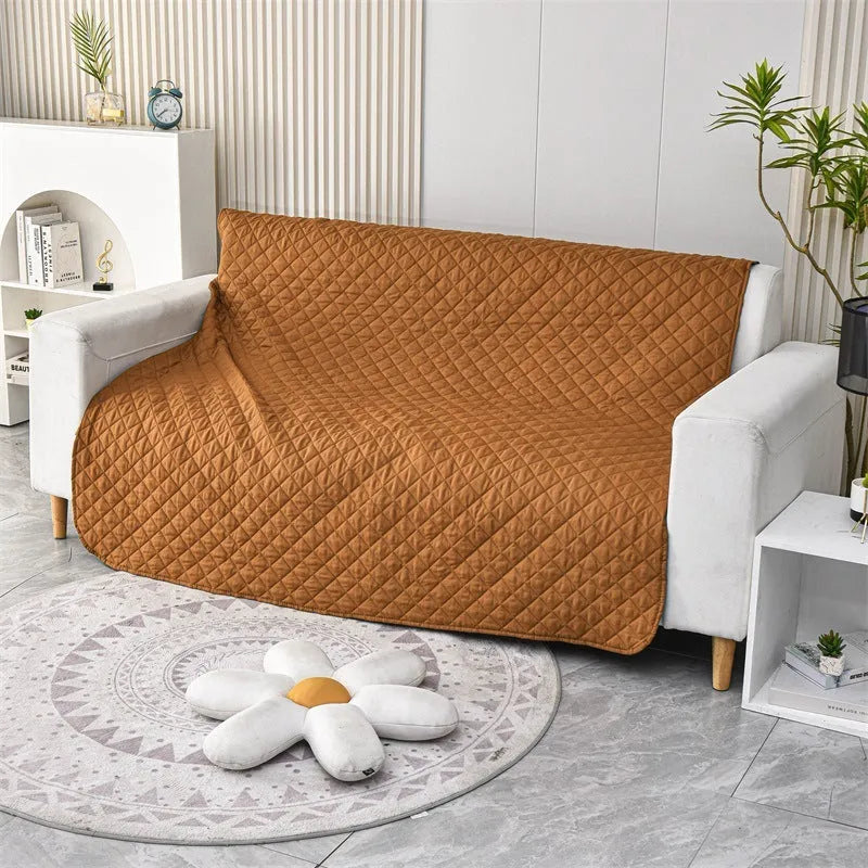 Reversible waterproof dog blanket on sofa showing two colour options, protecting furniture from pet accidents